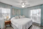 Primary bedroom with king bed, ceiling fan, and beach decor